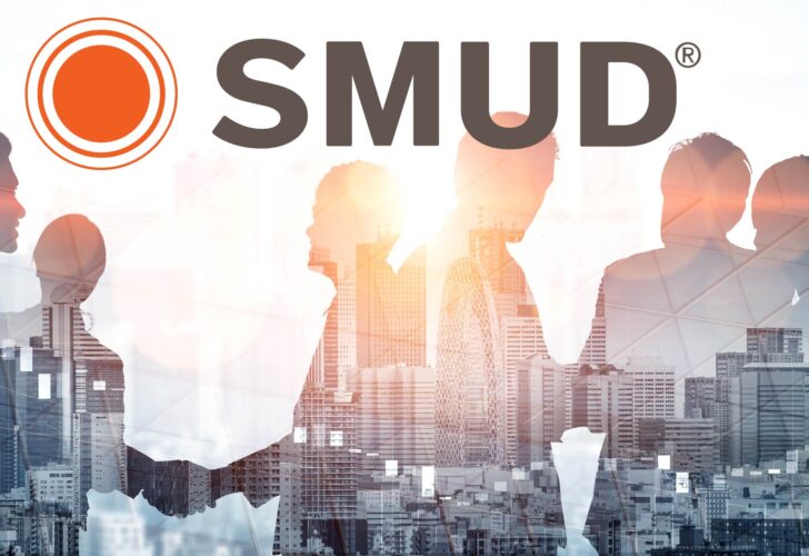 Silhouettes of professionals meet and collaborate, layered over a modern city skyline. The SMUD logo shines above, symbolizing innovation, energy, and community partnership.