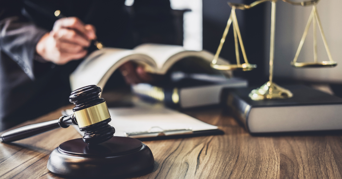 Gavel in the foreground with a judge in the background holding a book